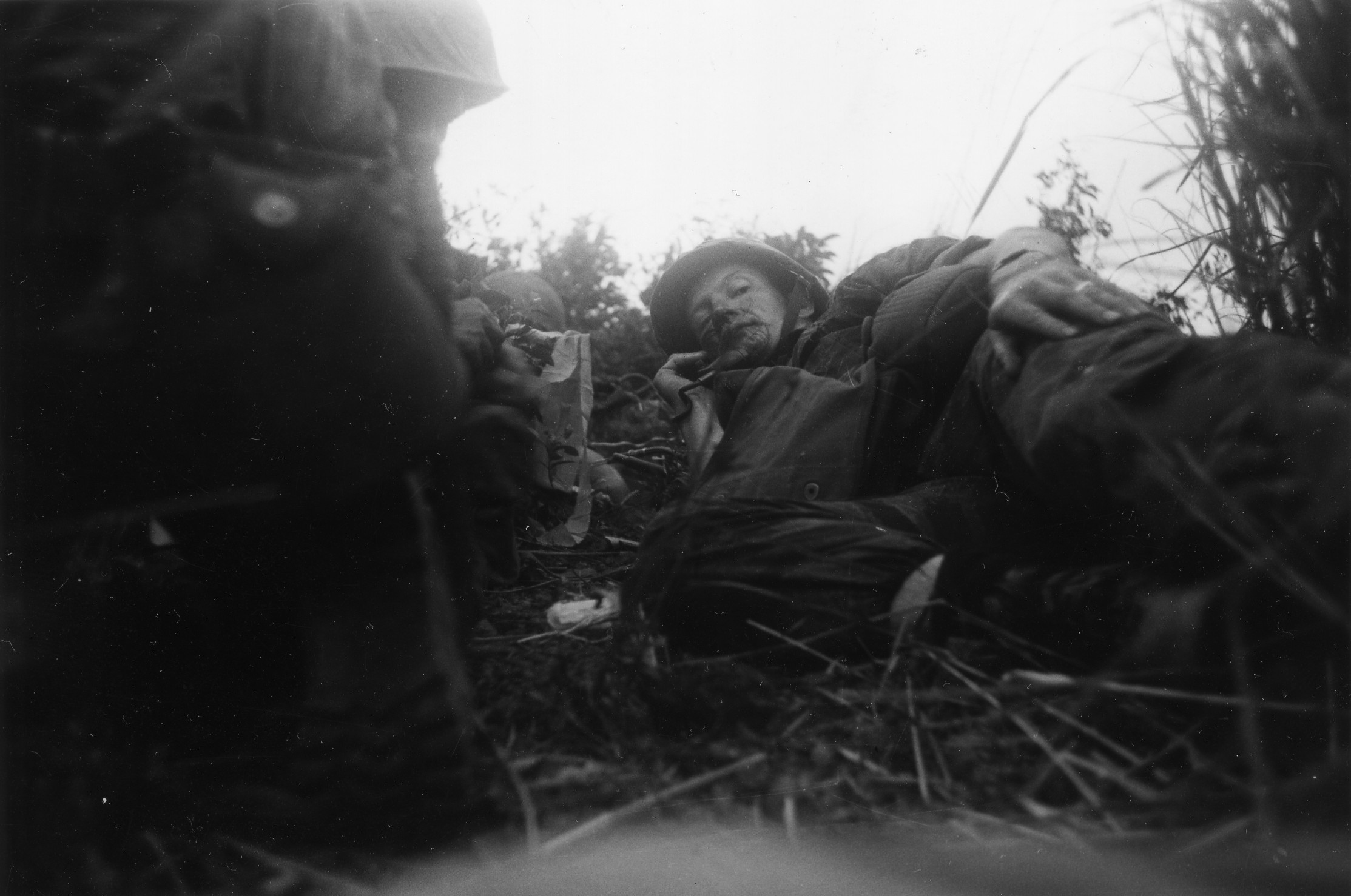 In the field: Wounded U.S. Marine Corps adviser Maj. William Leftwich Jr. shelters during a fire fight in Vietnam’s Binh Dinh province in 1965. | BUNYO ISHIKAWA