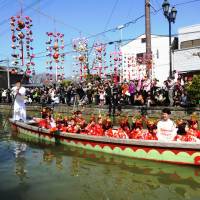  A boat in Yanagawa’s living doll parade drifts under the sagemon. | MANDY BARTOK