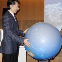 Professor Shinichi Takemura demonstrates his Tangible Earth, an interactive globe, with the head of UNISDR\'s risk knowledge section, Andrew Maskery. | UNISDR