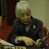 Michiko Kiyoka shows pictures of the family members she lost in the Great Tokyo Air Raid of March 10, 1945. | IAN MUNROE