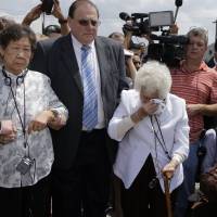 Remembrance: Ok Sun Lee, 87, wipes away tears as she stands with Il Chul Kang, 86, also a former \"comfort woman,\" at the dedication in August of a monument in Union City, New Jersey, to the mostly Asian women who were forced into prostitution for Japanese forces in World War II. | AP