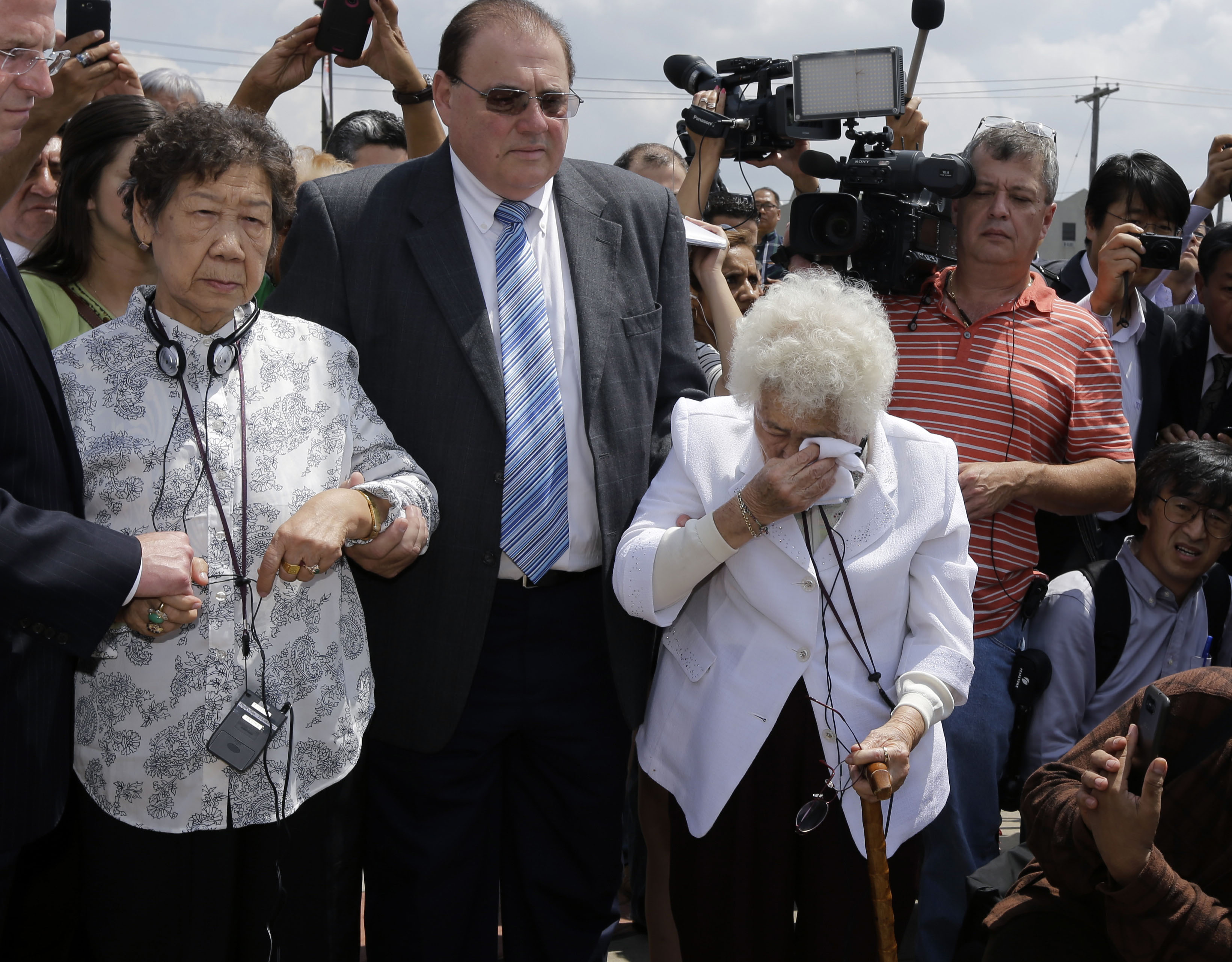 Remembrance: Ok Sun Lee, 87, wipes away tears as she stands with Il Chul Kang, 86, also a former 'comfort woman,' at the dedication in August of a monument in Union City, New Jersey, to the mostly Asian women who were forced into prostitution for Japanese forces in World War II. | AP