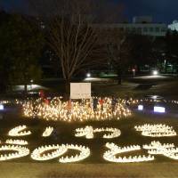 About 2,000 candles are lit at a park in Iwaki, Fukushima Prefecture, with a Japanese phrase meaning \"Iwaki-flame of hope,\" Sunday. | KYODO
