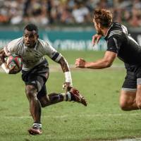 On the attack: Fiji\'s Jerry Tuwai (left) tries to evade New Zealand\'s Jo Webber during the final game of the Hong Kong Sevens on Sunday. | AFP-JIJI
