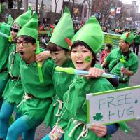 Revelers decked out in green participate in a St. Patrick\'s Day Parade on Sunday in Tokyo\'s trendy Omotesando district. About 1,500 people, including Irish Ambassador to Japan Anne Barrington, took part in the festivities. | YOSHIAKI MIURA