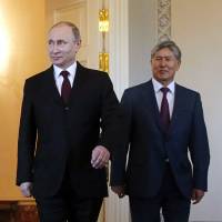 Russian President Vladimir Putin and Kyrgyz leader Almazbek Atambayev meet in St. Petersburg on Monday. Putin laughed off rumors over his 10-day absence, saying life would be \"boring without gossip.\" | REUTERS