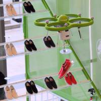 Crocs Japan GK\'s custom-built drone lifts a pair of the company\'s new Norlin sneakers from a display rack before delivering them to a staff member during a preview Thursday for its temporary \"store in the air\" in Tokyo Midtown. | SATOKO KAWASAKI