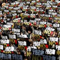 Protesters shout slogans and hold placards reading \"No to the Abe administration\" at a rally against Prime Minister Shinzo Abe\'s government in central Tokyo on Sunday. Organizers said more than 10,000 people participated in the event. | REUTERS