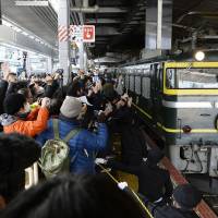 Railroad buffs gather at JR Osaka Station on Thursday to take photos of the luxury Twilight Express sleeper train before its final run. About 3,500 people saw off the train that carried passengers the 1,500 km between Osaka and Sapporo for 25 years. | KYODO