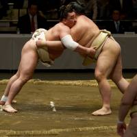 Eyes on: Yokozuna Harumafuji (left) fights an unidentified sumo wrestler while komusubi Ichinojo looks on during Wednesday’s open practice session at Tokyo’s Ryogoku Kokugikan. The Summer Grand Sumo Tournament starts on May 10 at the same venue. Hakuho out for No. 35, Henderson out just to survive