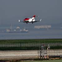 Honda Aircraft\'s HondaJet executive jet approaches Tokyo\'s Haneda airport on Thursday. The HondaJet will embark on a 13-nation sales promotion tour. | AFP-JIJI