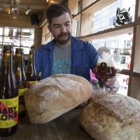 Sebastien Morvan, one of the founders of the Brussels Beer Project, examines a beer called Babylone, made from bread, at the Barbeton bar in central Brussels on Tuesday. | REUTERS