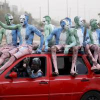 Supporters with painted bodies sit on a vehicle as they celebrate outside the office of the All Progressives Congress (APC) party after President-elect Muhammadu Buhari won the presidential election, along a street in Abuja on Wednesday. Biometrics and online campaigning have been credited with aiding his victory. | REUTERS