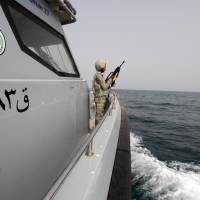 A Saudi border guard watches Wednesday from a boat off the coast of the Red Sea on Saudi Arabia\'s maritime border with Yemen, near Jizan. Iran sent two warships to the Gulf of Aden on Wednesday, state media reported, establishing a military presence off the coast of Yemen where Saudi Arabia is leading a bombing campaign to oust the Iran-allied Houthi movement. | REUTERS