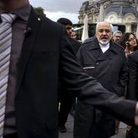 Iranian Foreign Minister Javad Zarif talks to members of the media while walking through a courtyard at the Beau Rivage Palace Hotel during an extended round of talks Wednesday in Lausanne, Switzerland. Zarif said on Wednesday that the nuclear talks with the major powers could succeed if they have political will to resolve Iran\'s 12-year old nuclear standoff. | REUTERS