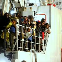 Rescued migrants wait to disembark from an Italian Coast Guard ship in Palermo, Sicily, on Tuesday. Some 150 rescued survivors from a shipwreck off Libya said 400 of their fellow migrants drowned. Shipwreck off Libya claimed 400 migrants, survivors say