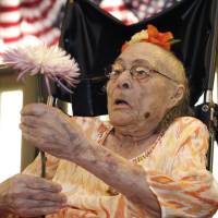 Gertrude Weaver last July 3 holds a flower given to her a day before her 116th birthday at Silver Oaks Health and Rehabilitation Center in Camden, Arkansas. Just days after becoming the world\'s oldest documented person, 116-year-old Weaver died Monday in Arkansas. | AP