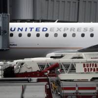 Emergency vehicles surround a SkyWest Airlines plane, operating as United Express, that made an emergency landing at Buffalo Niagara International Airport, Wednesday in Cheektowaga, New York. A SkyWest spokeswoman said one passenger aboard Flight 5622, lost consciousness and the pilots rapidly descended \"out of an abundance of caution.\" | AP