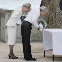 Emperor Akihito and Empress Michiko offer flowers Thursday at a cenotaph in honor of the war dead on Peleliu island, Palau. | KYODO