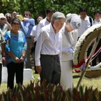 Emperor Akihito and Empress Michiko offer flowers at a monument for Japanese and U.S. troops who died during a vicious World War II battle on Peleliu Island, during the Imperial Couple\'s visit to Palau on Thursday. | POOL / KYODO
