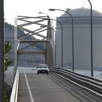 A car drives away from the No. 2 reactor at Kansai Electric Power Co.\'s Mihama nuclear power plant in Mihama, Fukui Prefecture, in July 2011. | REUTERS
