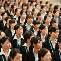 New employees of Seven &amp; I Holdings Co. attend an initiation ceremony in Tokyo on March 19. Opponents of a bill that would introduce a \"white-collar exemption system\" worry that, if passed, businesses will seek to lower the law\'s income cap in the future. | BLOOMBERG