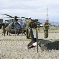 The tail rotor from a Ground Self-Defense Force OH-6D helicopter lies in a rice field in Sendai after the chopper made a crash landing Monday. | KYODO