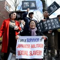 Former \"comfort woman\" Yong Soo Lee, 88, of South Korea, protests outside Harvard\'s John F. Kennedy School of Government during Prime Minister Shinzo Abe\'s visit to Harvard University in Cambridge, Massachusetts, on April 27. | REUTERS