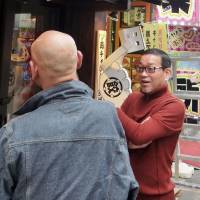 Hidemori Gen (right), head of support group Nihon Kakekomidera, chats with a former prison inmate April 16 outside an \"izakaya\" pub in Tokyo\'s Kabukicho district where he will start working. | KYODO