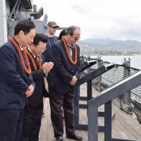 Kampei Shimoide, mayor of Minamikyushu, Kagoshima Prefecture (second from left), prays for a Kamikaze pilot who died in the war, during a visit to the Battleship Missouri Memorial in Hawaii on Saturday. | KYODO