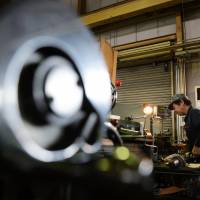 An employee operates a metal lathe at an Osaka Machine Tool Co. factory in Higashiosaka, Osaka Prefecture, on Tuesday. | BLOOMBERG