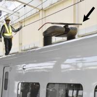 A railway worker checks a broken overhead line of a bullet train at Koriyama Station in Fukushima Prefecture on Wednesday. The services on the Tohoku Shinkansen Line in eastern and northeastern Japan were suspended for about 4&#189; hours, affecting thousands of people traveling on Golden Week. | KYODO