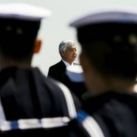 Defense Minister Gen Nakatani addresses members of the Maritime Self-Defense Force during the handover ceremony for the warship Izumo at the Japan United Marine shipyard in Yokohama on March 25. Japan will host its first international defense trade show next month in the city. | REUTERS