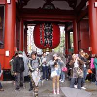 Thai tourists take photos in front of the Kaminarimon Gate at Sensoji Temple on Tuesday. Thais flock to Japan for holiday, ignore freeze on flight increases