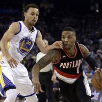 A handful: Portland’s Damian Lillard drives past Golden State’s Stephen Curry in the first half on Thursday night. The Warriors ran past the Trail Blazers 116-105. Curry pumps in 45 as Warriors rack up 64th win of season