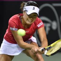 Singular focus: Kurumi Nara hits a return against Olga Govortsova of Belarus during their singles match on Saturday. Nara earned a 6-4, 4-6, 6-2 triumph. | AFP-JIJI