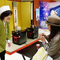 A tourist from Taiwan drinks green tea at the \"foreign customers\' salon\" that opened Monday at Kintetsu Department Store\'s flagship outlet in Abeno Harukasu, the tallest building in Japan, in the city of Osaka. | KYODO