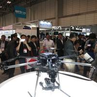 Visitors inspect one of the latest models on offer, a hexacopter, at the International Drone Expo at Makuhari Messe convention hall in Chiba Prefecture. | KAZUAKI NAGATA