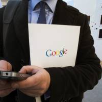 In this Dec. 10, 2013, file photo, a reporter uses his smartphone during a presentation for the new Google cultural institute in Paris. More Google search requests are now being made on mobile devices than personal computers in the U.S. and many other parts of the world. The milestone was announced at a digital advertising conference on Tuesday. | AP