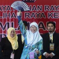 Wan Azizah, the wife of Malaysian opposition leader Anwar Ibrahim, celebrates after winning a by-election in Permatang Pauh in the northern state of Penang on Thursday. | AFP-JIJI