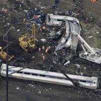 Emergency personnel work at the scene of a deadly Amtrak train wreck Wednesday in Philadelphia. | AP
