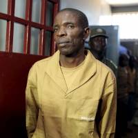 Sect leader Jose Kalupeteka is escorted by police in Huambo, Angola, on Tuesday. Kalupeteka is a popular preacher against authority who says the world will end on Dec. 31. | REUTERS