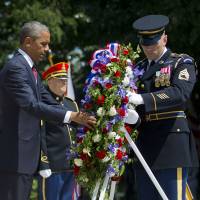 President Barack Obama and with the aid of Sgt. 1st Class John C. Wirth lays a wreath at the Tomb of the Unknowns, on Memorial Day, Monday at Arlington National Cemetery in Arlington, Virginia. | AP