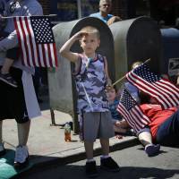 Rocco Struncius salutes as soldiers walk by during a Memorial Day parade in the Glenwood neighborhood of New York on Monday. President Barack Obama saluted Americans who died in battle Monday, noting the first Memorial Day in 14 years without U.S. forces involved in a major ground war. | AP