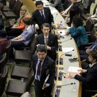 North Korean diplomats (center) leave a  panel discussion at United Nations headquarters Thursday on North Korean human rights abuses. The panel discussion briefly turned chaotic as North Korean diplomats insisted on reading a statement, amid shouts from defectors, and then stormed out of the chamber. | AP