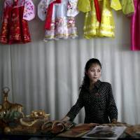 A woman stands in a gift shop in the North Korean city of Rason, part of the special economic zone northeast of Pyongyang, in August 2011. North Korea is a militarized, male-dominated society, but it is women who are making the money as the insular nation allows an unofficial market-based economy to take shape. | REUTERS