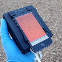 This handout photo provided by Daniel A. Fletcher shows a Cellscope being used in an outdoor setting. Prick a finger and have the blood checked for parasites by smartphone. Scientists are turning those ubiquitous phones into microscopes and other medical tools that could help fight diseases in remote parts of the world. In the newest work, University of California, Berkeley, researchers used a smartphone-run video microscope to target a challenge in parts of Central Africa — some devastating infections caused by tiny parasitic worms. Microscope in smartphone can detect parasites in blood