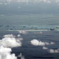 This photo taken through a  window of a military plane shows China\'s alleged ongoing reclamation of Mischief Reef in the Spratly Islands in the South China Sea on Monday. Gen. Gregorio Pio Catapang, the Philippines\' military chief, has flown to Pagasa Island, a Filipino-occupied island in the South China Sea, amid territorial disputes in the area with China, vowing to defend the islet and help the mayor develop tourism and marine resources there. | RITCHIE B. TONGO / POOL PHOTO VIA AP