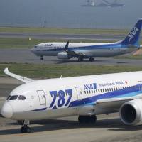A Boeing Co. 787 Dreamliner (bottom) owned by All Nippon Airways Co. (ANA) taxies at Tokyo\'s Haneda Airport in April. ANA and Japan Airlines Co. said Friday that their Dreamliners won\'t be affected by a recently discovered software error that could turn the planes off in mid-flight. | BLOOMBERG