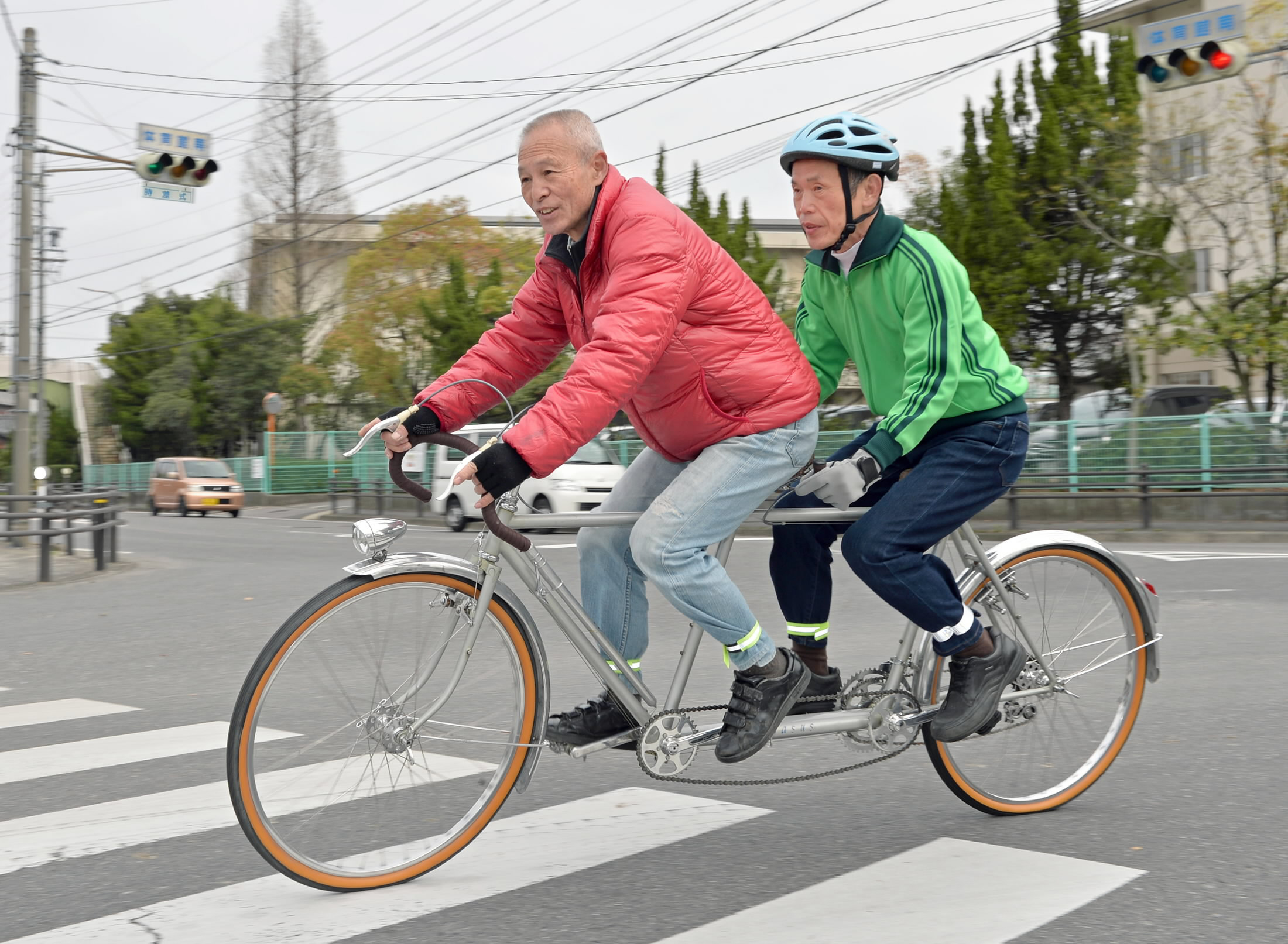 Tadao Takahashi (left) and Hiroshi Yamada ride a tandem bike in Kariya, Aichi Prefecture. | CHUNICHI SHIMBUN